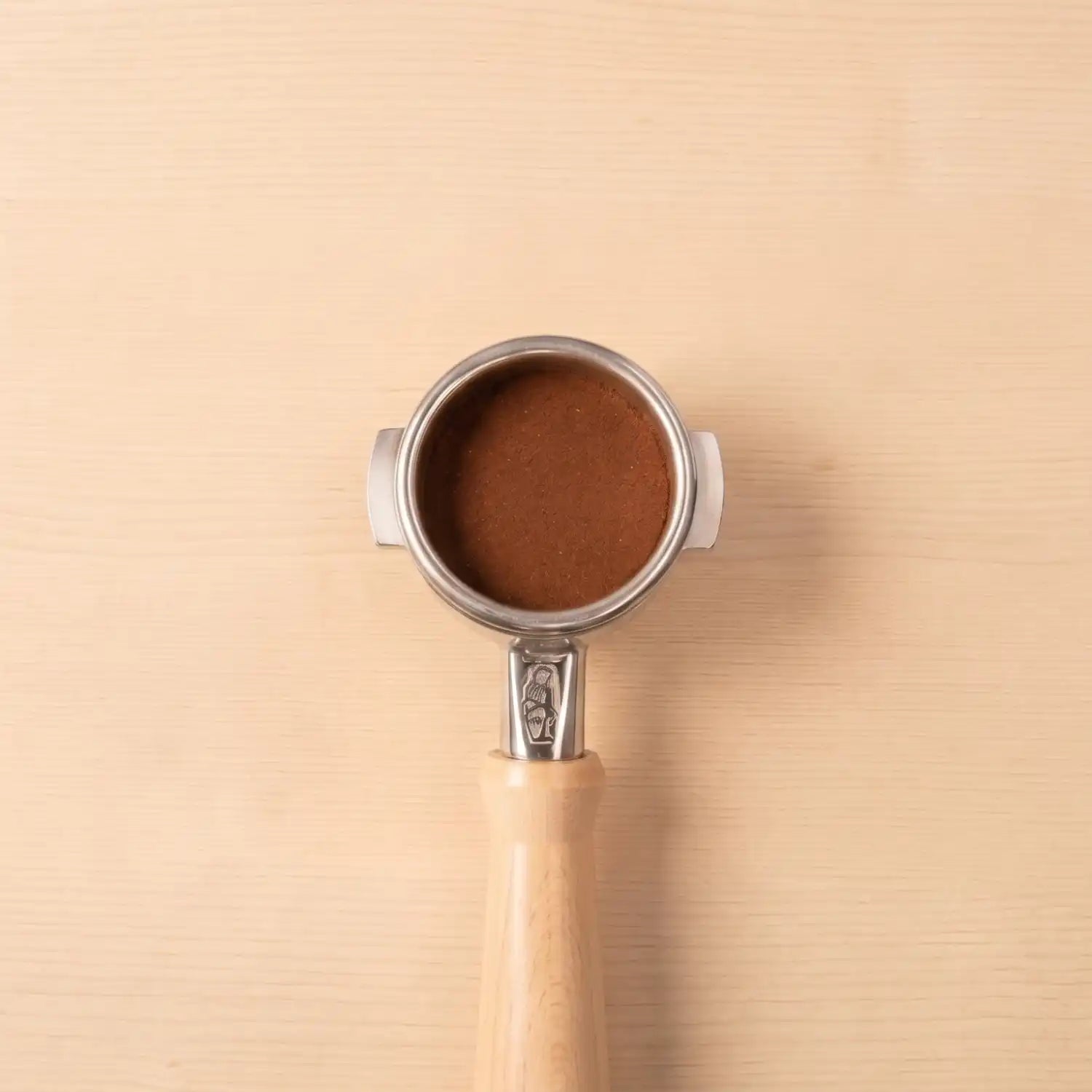 La Marzocco Siebträger mit gemahlenem Specialty Coffee auf einem Hintergrund aus hellem Holz